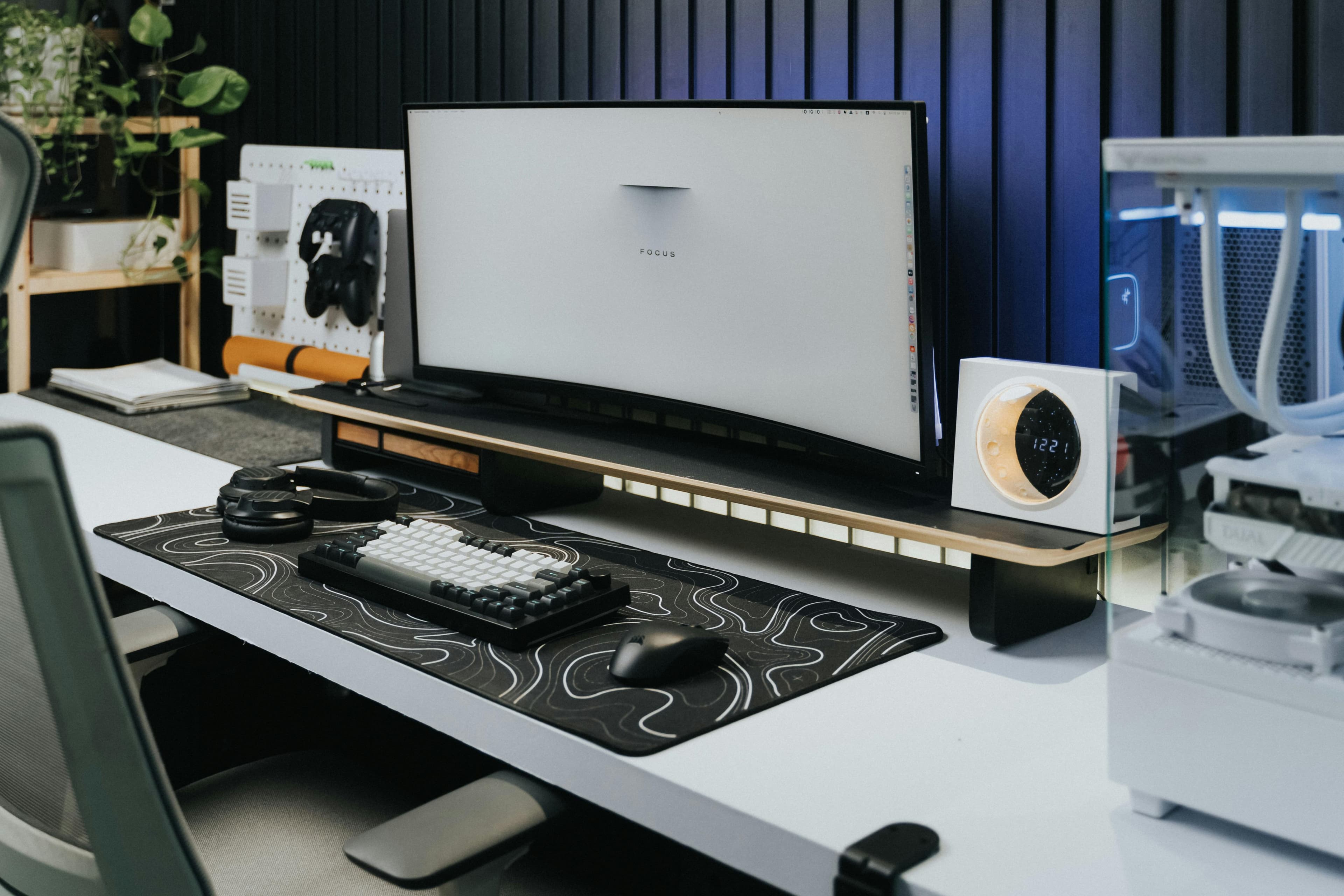 Desk setup with a patterned deskmat, keyboard, and monitor